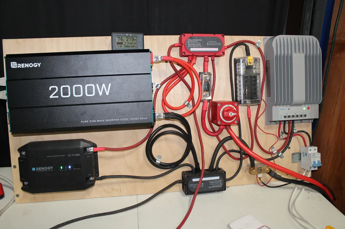 Example complete 12V off-grid system wiring board with inverter, DC-DC charger, MPPT charge controller, bus bars, fuse block, and disconnect switch